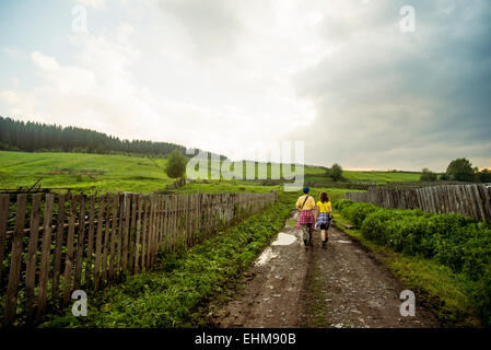 Coppia caucasica camminando su rurale strada sterrata Foto Stock