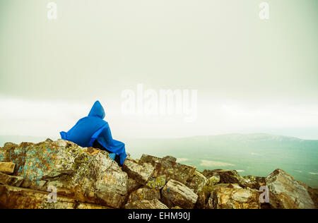 Escursionista caucasica seduti sulla collina rocciosa Foto Stock