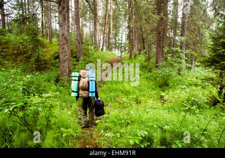 Escursionista caucasica zaino porta in foresta Foto Stock