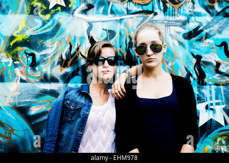 Donne caucasiche in posa vicino al muro di graffiti Foto Stock