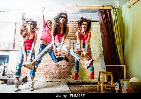 Donne caucasici jumping in salotto Foto Stock