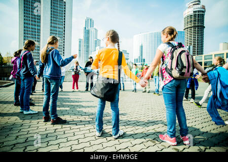 Caucasian bambini che giocano in piazza della città Foto Stock