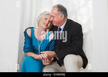 Sorridente coppia di anziani in formale abbracci di usura Foto Stock