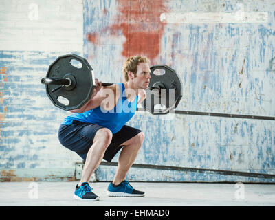 Uomo caucasico sollevamento pesi in magazzino Foto Stock