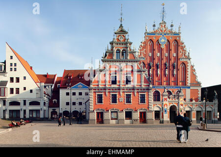 I turisti a piedi sulla piazza del Municipio e nella Casa delle Teste Nere di Riga Foto Stock