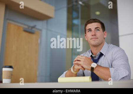 Imprenditore caucasico seduto in ufficio Foto Stock