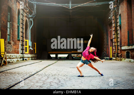 Caucasian woman dancing sulla strada di ciottoli Foto Stock