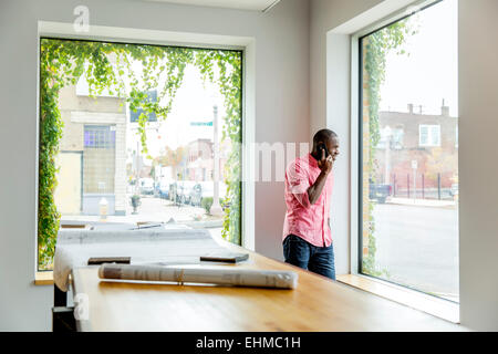 African American businessman parlando al cellulare in ufficio Foto Stock