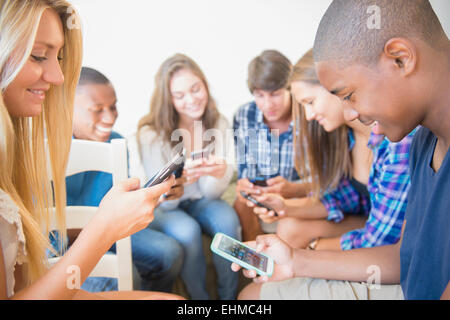 Gli adolescenti utilizzando i telefoni cellulari Foto Stock