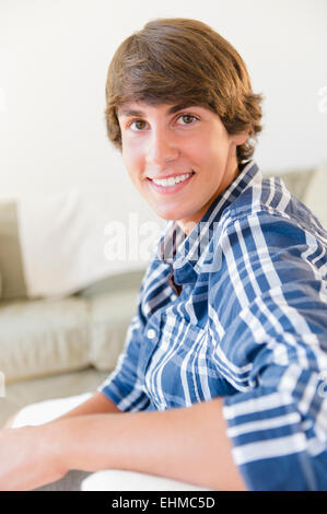 Caucasian ragazzo adolescente sorridente in salotto Foto Stock