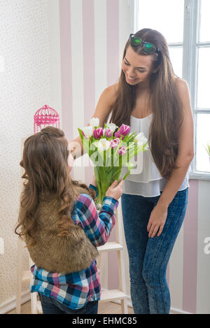 La festa della mamma - ragazza dà la sua mamma un grande mazzo di tulipani, toccando Foto Stock