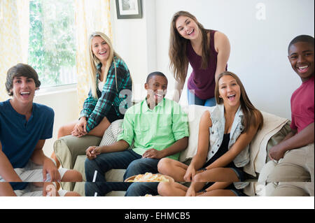 Gli adolescenti sorridente sul divano a parte Foto Stock