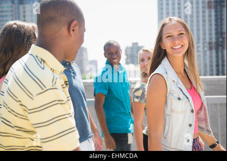 Sorridente adolescenti camminando sul tetto urbano Foto Stock