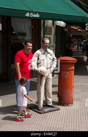 Argentina Buenos Aires Recoleta, i visitatori in posa con la statua di motor racing driver Juan Manuel Fangio al di fuori La Biela cafe Foto Stock