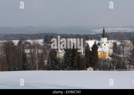 Paesaggio invernale con il villaggio di Jindrichovice in background in Boemia occidentale, Repubblica Ceca. Foto Stock