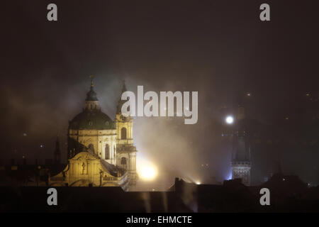 Notte di nebbia che copre Saint Nicholas' chiesa nel quartiere di Mala Strana di Praga, Repubblica Ceca. Foto Stock