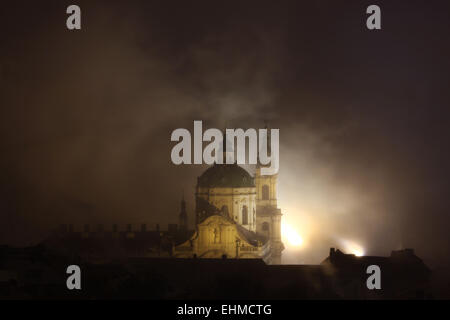 Notte di nebbia che copre Saint Nicholas' chiesa nel quartiere di Mala Strana di Praga, Repubblica Ceca. Foto Stock