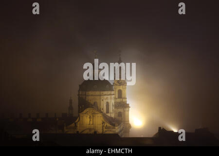 Notte di nebbia che copre Saint Nicholas' chiesa nel quartiere di Mala Strana di Praga, Repubblica Ceca. Foto Stock