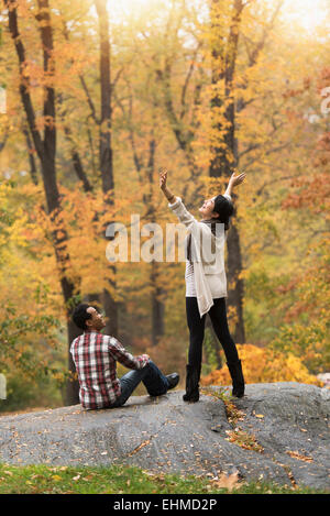 Donna tifo con le braccia aperte vicino al ragazzo nel parco Foto Stock