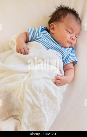 Razza mista baby dormire nel letto Foto Stock