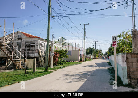 Back Street in Caye Caulker mostra case tipiche e strada sterrata Foto Stock