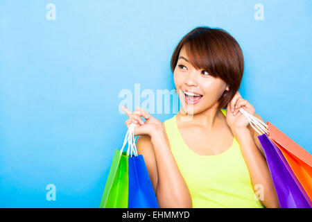 Giovane donna azienda shopping bags e guardando lato Foto Stock