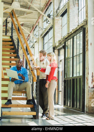 La gente di affari con computer portatile su scala Foto Stock