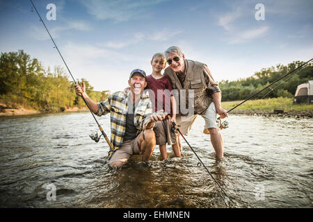 Tre generazioni di uomini caucasici la pesca in fiume Foto Stock