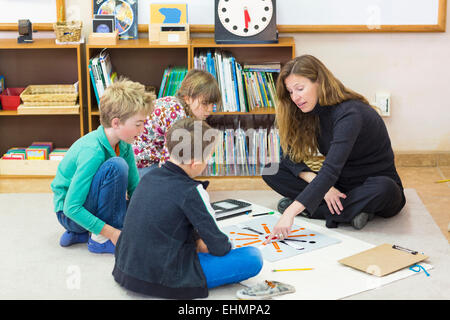 Insegnante Montessori aiutare gli studenti in aula Foto Stock