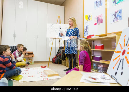 Ragazza dando presentazione ai compagni di classe Foto Stock