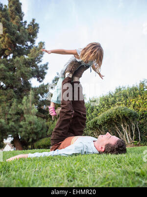 Caucasian padre e figlia giocando in erba Foto Stock