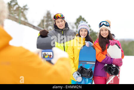 Happy amici con racchette da neve e lo smartphone Foto Stock