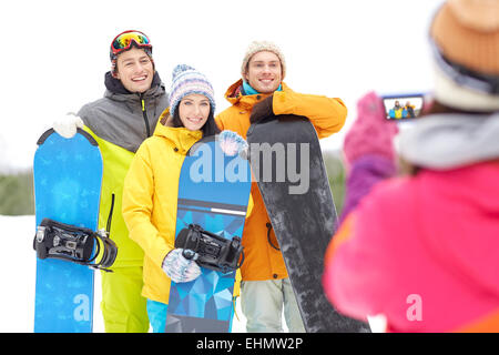 Happy amici con racchette da neve e lo smartphone Foto Stock