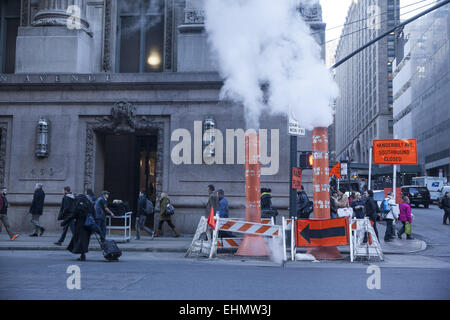 Il vapore proveniente da sotto la strada è una vista regolari nel centro di Manhattan tra l'edificio dell'ufficio. Foto Stock