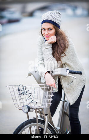 Donna che utilizza un moto Velib a Parigi, Francia. Foto Stock