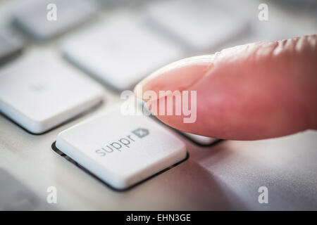 Donna premendo un tasto sulla tastiera di un computer. Foto Stock