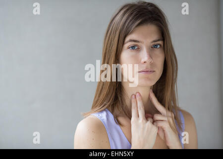 Donna auto-esaminando la sua gola. Foto Stock