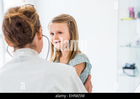 Medico esaminando un 4 anno vecchia ragazza con uno stetoscopio. Foto Stock