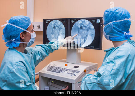 Chirurgo di eseguire impianto cocleare chirurgia, un'operazione di impiantazione di un piccolo dispositivo elettronico utilizzato per fornire un senso di suono a una persona non udente, ospedale di Limoges, Francia. Foto Stock