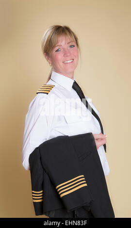 Attraente femmina capitano della compagnia aerea in piedi in uniforme di camicia di contenimento Foto Stock