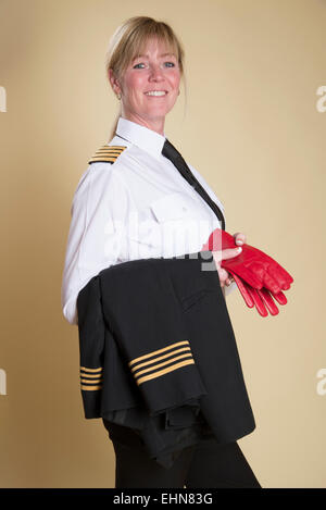 Attraente femmina capitano della compagnia aerea in piedi in uniforme di camicia di contenimento Foto Stock