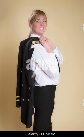 Attraente femmina capitano della compagnia aerea in piedi in uniforme di camicia di contenimento Foto Stock