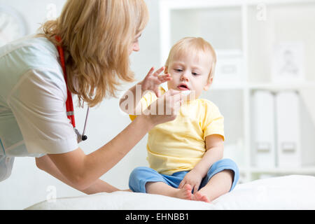 Medico dando medicamento con un cucchiaio Foto Stock
