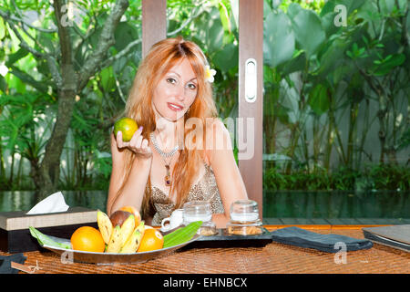 La giovane donna bella mangia frutta Foto Stock