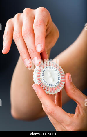 Donna prendendo una terapia di sostituzione ormonale pillole. Foto Stock
