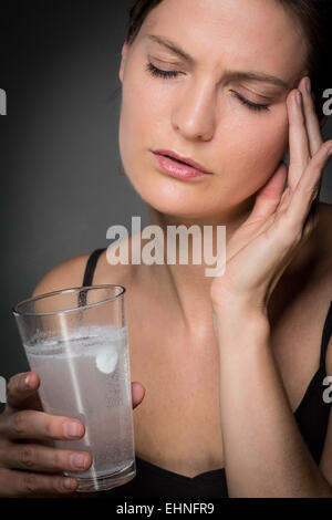 Donna di prendere una compressa effervescente. Foto Stock