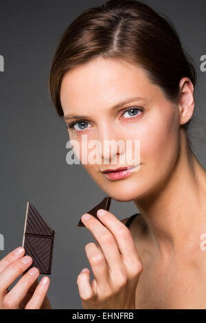 Donna di mangiare cioccolato. Foto Stock