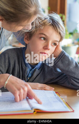 Madre controllo homeworks di suo figlio. Foto Stock