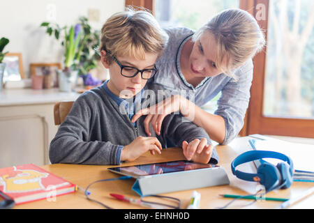 8 anno vecchio ragazzo utilizzando computer tablet. Foto Stock