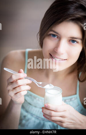 Donna di mangiare yogurt. Foto Stock